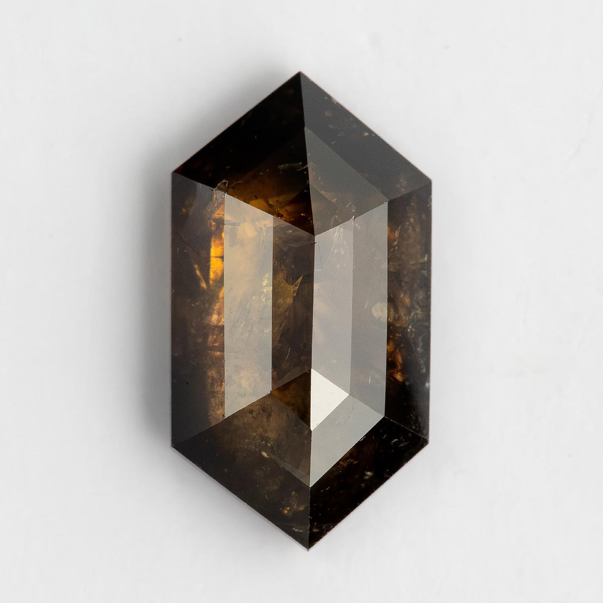 Isolated face-up view of the dark brown elongated hexagon diamond showing its complete outline and facet pattern.