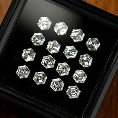 Oblique close-up of diamonds in a black tray, showing bright and dark step-facet reflections.