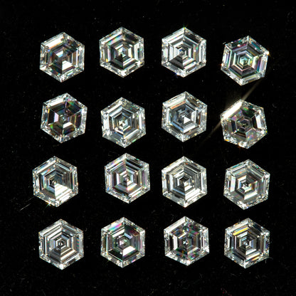Face-up view of photographed hexagonal step-cut diamonds arranged in a black tray, showing concentric facets and varied reflections.