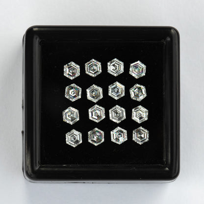 Straight-on black tray of arranged face-up hexagonal diamonds against a pale background.