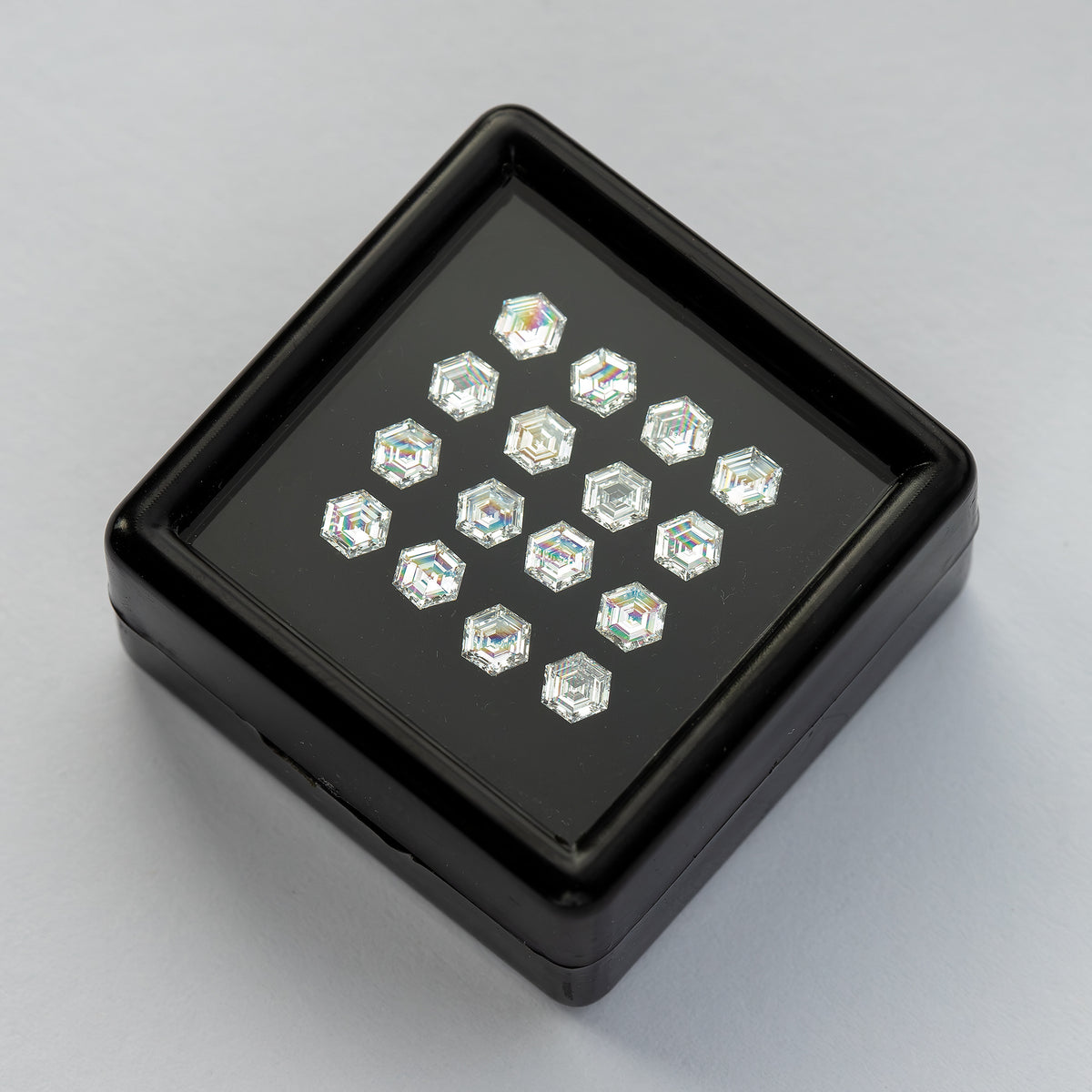 Black diamond tray set diagonally on a white surface, showing the arranged six-sided stones.