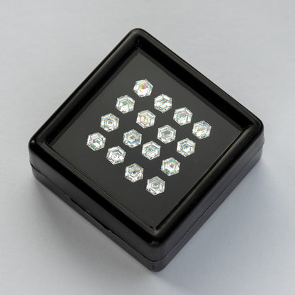 Black diamond tray set diagonally on a white surface, showing the arranged six-sided stones.