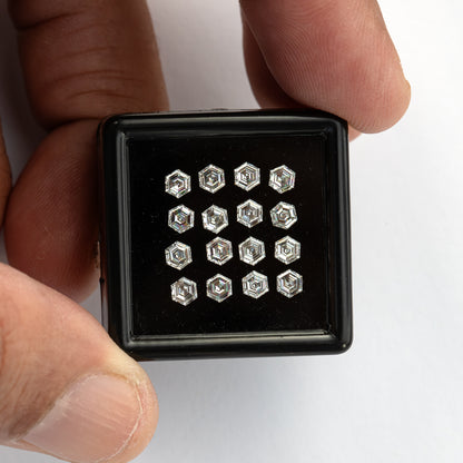 Wider view of a black tray held in a hand, giving size context for the small hexagonal diamonds.