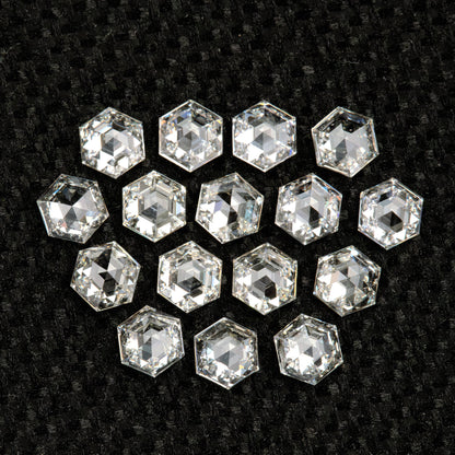 Hexagonal diamonds arranged on black fabric with their reverse-facing facets catching pale light.