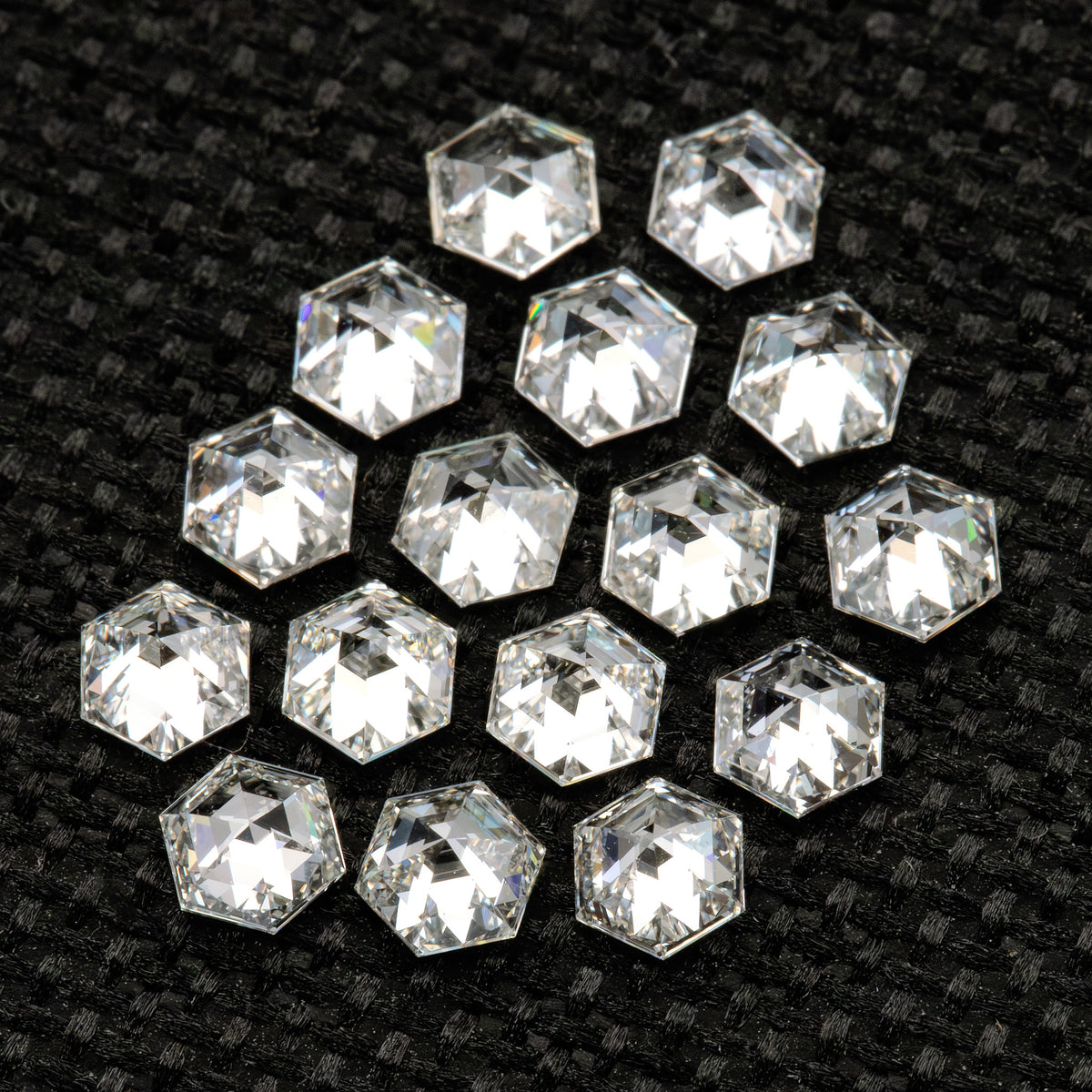 Closer angled view of the reverse-facing hexagonal diamond group on textured black fabric.