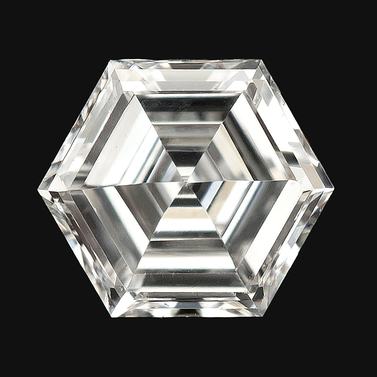 Isolated close-up of a hexagonal diamond against a plain black background, showing concentric step facets.