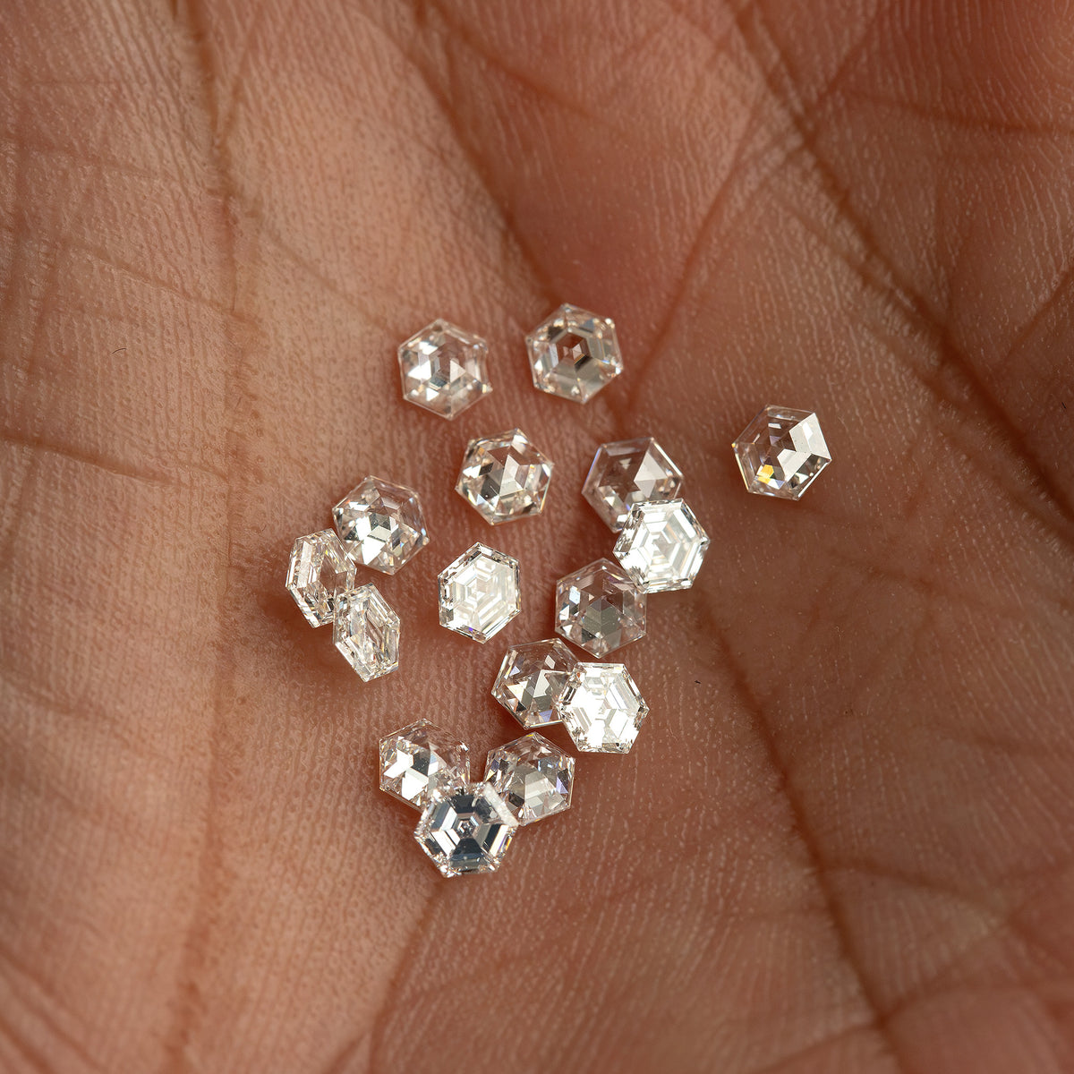 Closer view of the hexagonal diamond group resting in a palm, showing outlines at different angles.