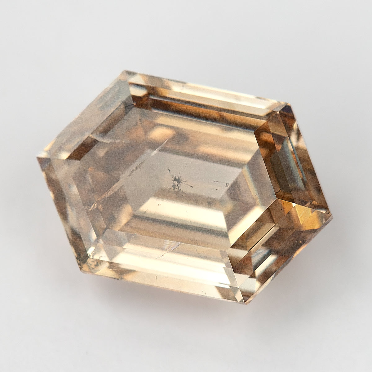 Face-up macro at a light angle showing pale brown appearance. IGI-HEXA-5925-0110CT.