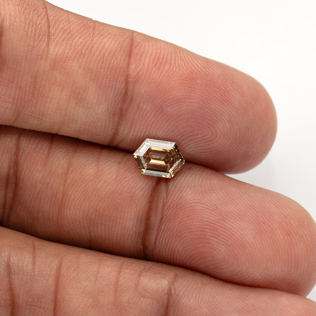Angled finger-scale view showing facet reflections. IGI-HEXA-5925-0110CT.
