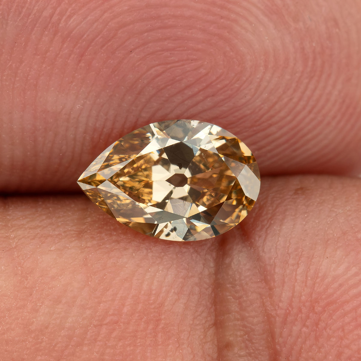Face-up macro on fingertips, showing internal features and large culet. IGI-PS-5923-0103CT.