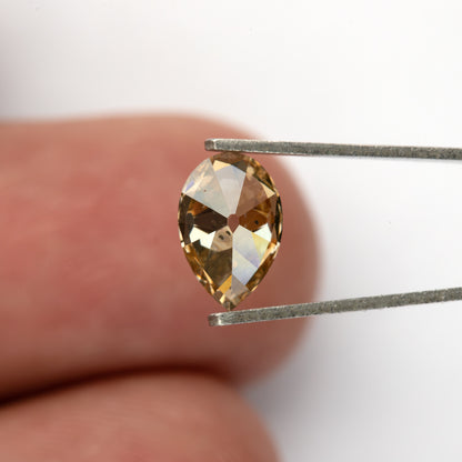 Wider pavilion view in tweezers against a fingertip. IGI-PS-5923-0103CT.