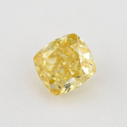 Tilted crown view of the yellow cushion-shaped natural diamond, showing a different pattern of bright and dark facet reflections.