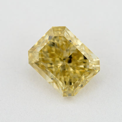 Face-up close-up of the yellow radiant diamond on a pale background, showing its complete outline and crown facet reflections.