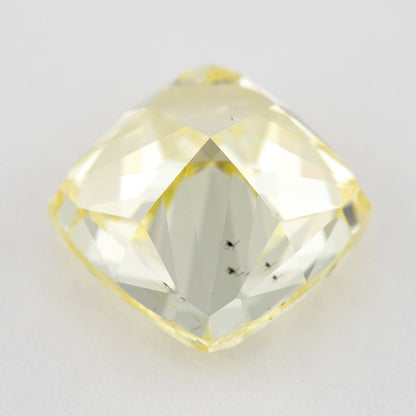 Back view of the yellow cushion-shaped natural diamond, showing broad pavilion facets and dark internal characteristics.