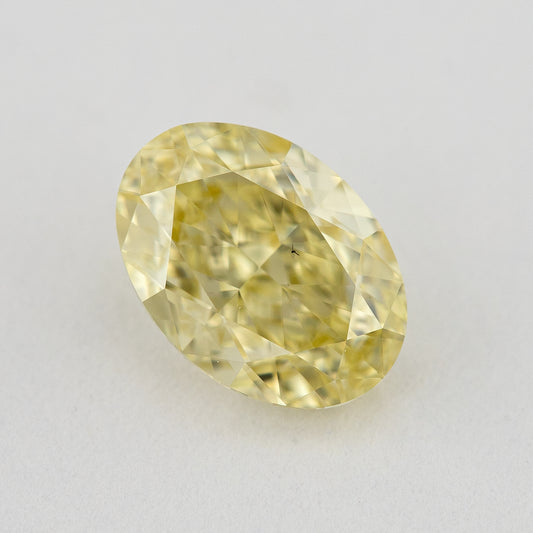 Face-up close-up of the yellow oval diamond on a pale background, showing its complete outline and crown facet reflections.
