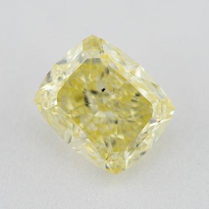Face-up close-up of the yellow cushion diamond on a pale background, showing its complete outline and crown facet reflections.