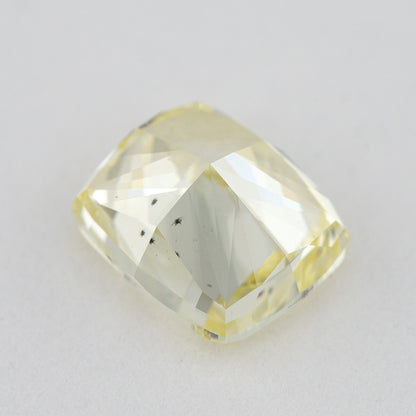 Low tilted view of the yellow cushion diamond, showing broad pavilion facets and the depth below its crown.