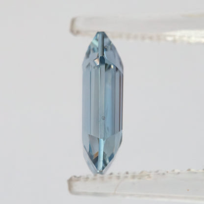Side profile view of shallow octagonal sapphire held in tweezers revealing thin profile.