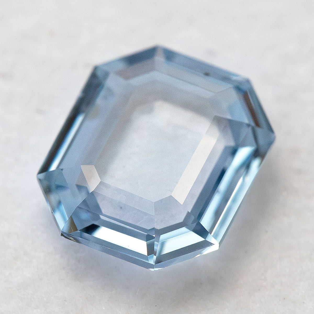 High-angle view of octagonal step cut light blue sapphire showing facet symmetry.