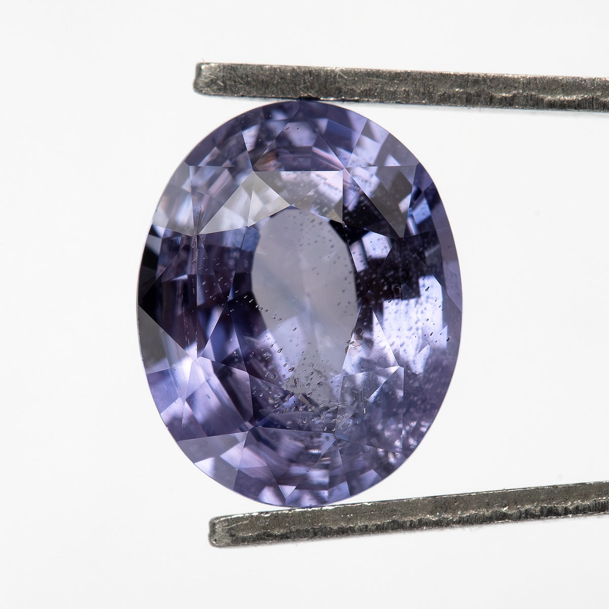 Lavender-blue oval sapphire with visible inclusions viewed face-up. View 16.
