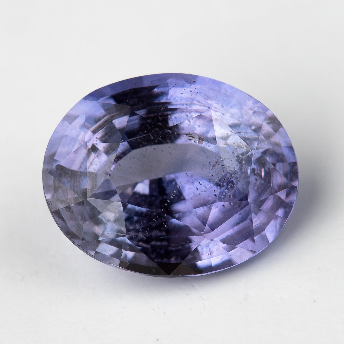 Lavender-blue oval sapphire with visible inclusions viewed face-up. View 2.