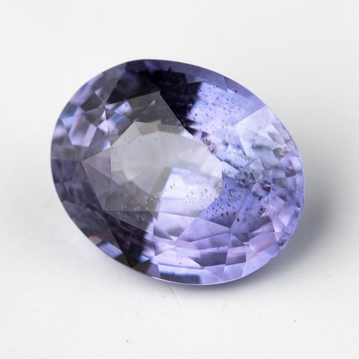 Lavender-blue oval sapphire with visible inclusions viewed face-up. View 9.