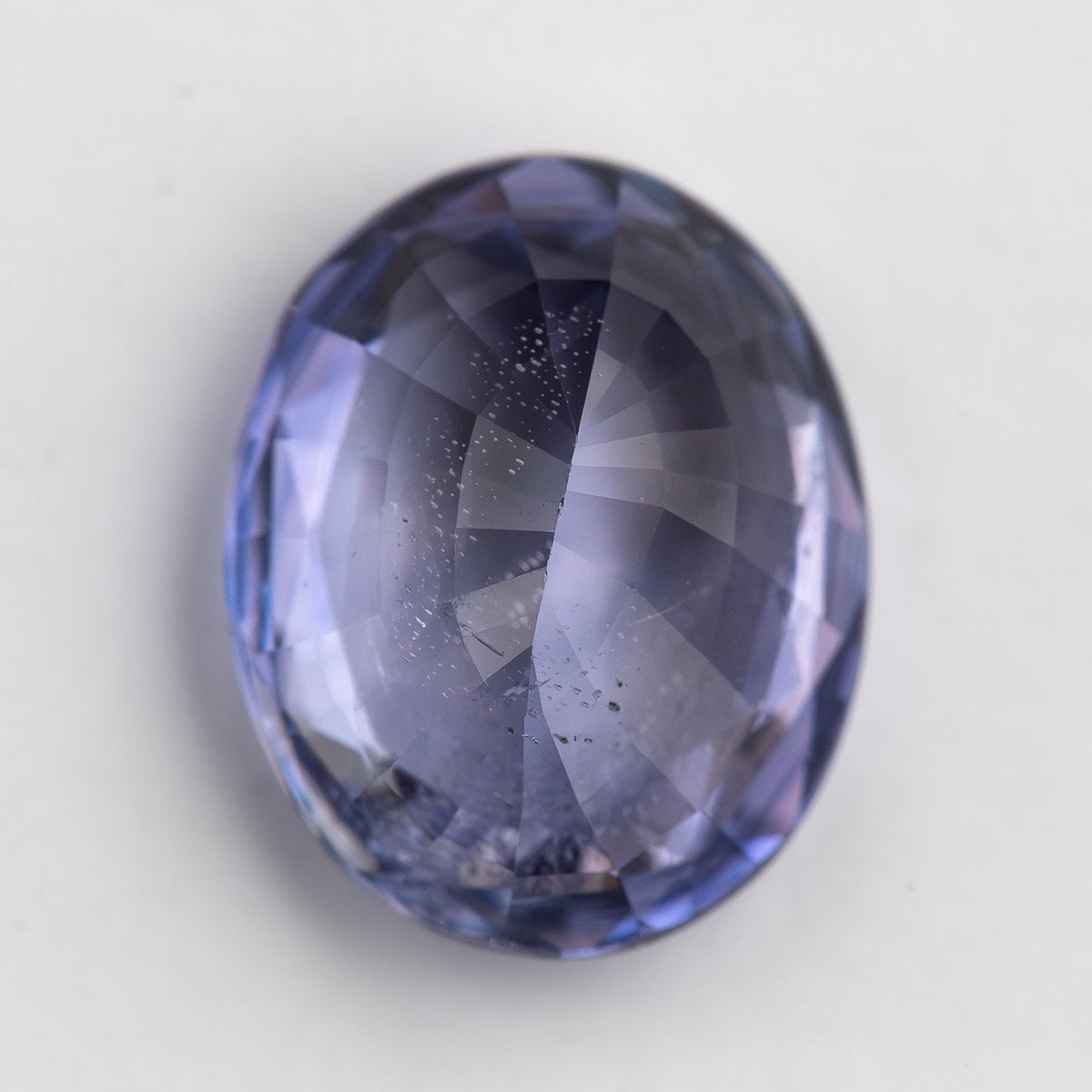 Lavender-blue oval sapphire with visible inclusions viewed from the pavilion side. View 18.