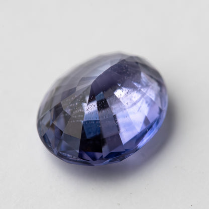 Lavender-blue oval sapphire with visible inclusions shown at an angle from the pavilion side. View 15.