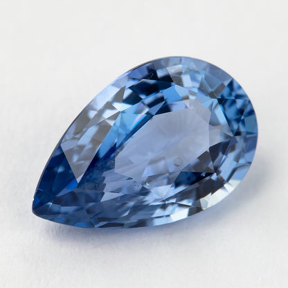 Angled view of the pear sapphire, showing a different reflection pattern and medium-blue flashes.