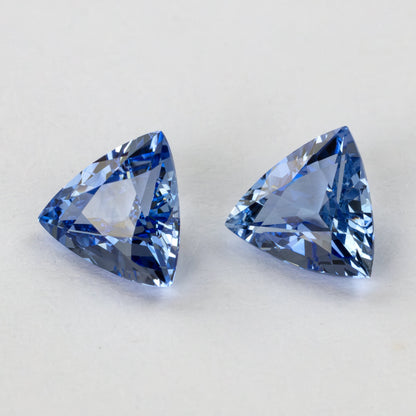 Two blue trillion-cut gemstones shown with slight variations in light reflection.