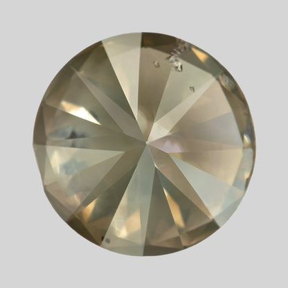 Back view of KL444 on a light background, with pavilion facets meeting at the center and cavities near the upper edge.