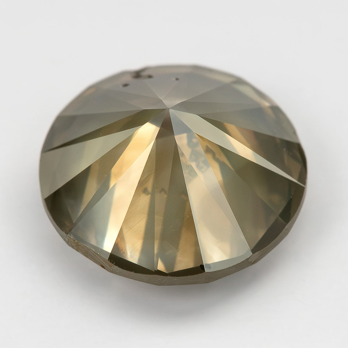 Low angled view of KL444 resting face-down, showing its pointed pavilion and broad reflective facets.