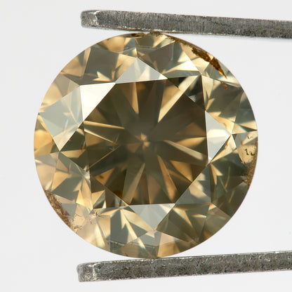 Face-up view of the round brilliant diamond held in tweezers, showing olive champagne-brown color, bright pale-yellow facets, gray-green reflections and visible brown girdle features.