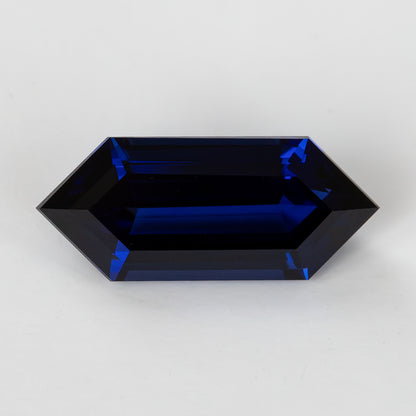Centered face-up view showing the blue sapphire’s pointed ends, straight sides and long parallel step facets.