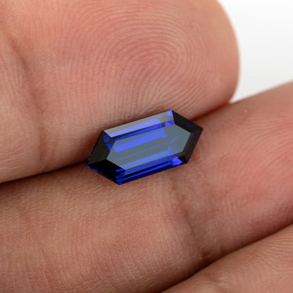 Angled fingertip-scale view showing blue border facets around a reflective central table.