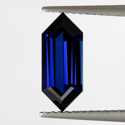 Upright tweezers view from another tilt, showing the long sapphire’s blue center and pointed ends.