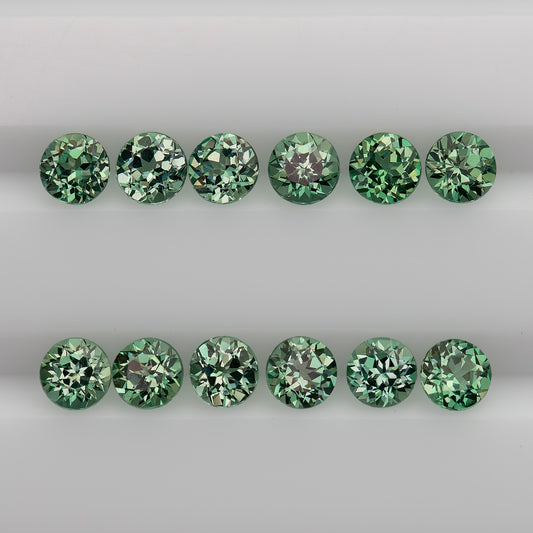 Representative mint-green round lab-grown sapphire stock arranged table-up in two rows, showing flower-style faceting; sold per stone.