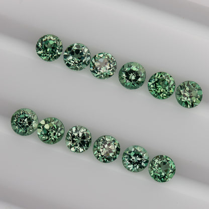 Mint-green round sapphire stock seen obliquely in two rows, with tables and crown facets still visible.
