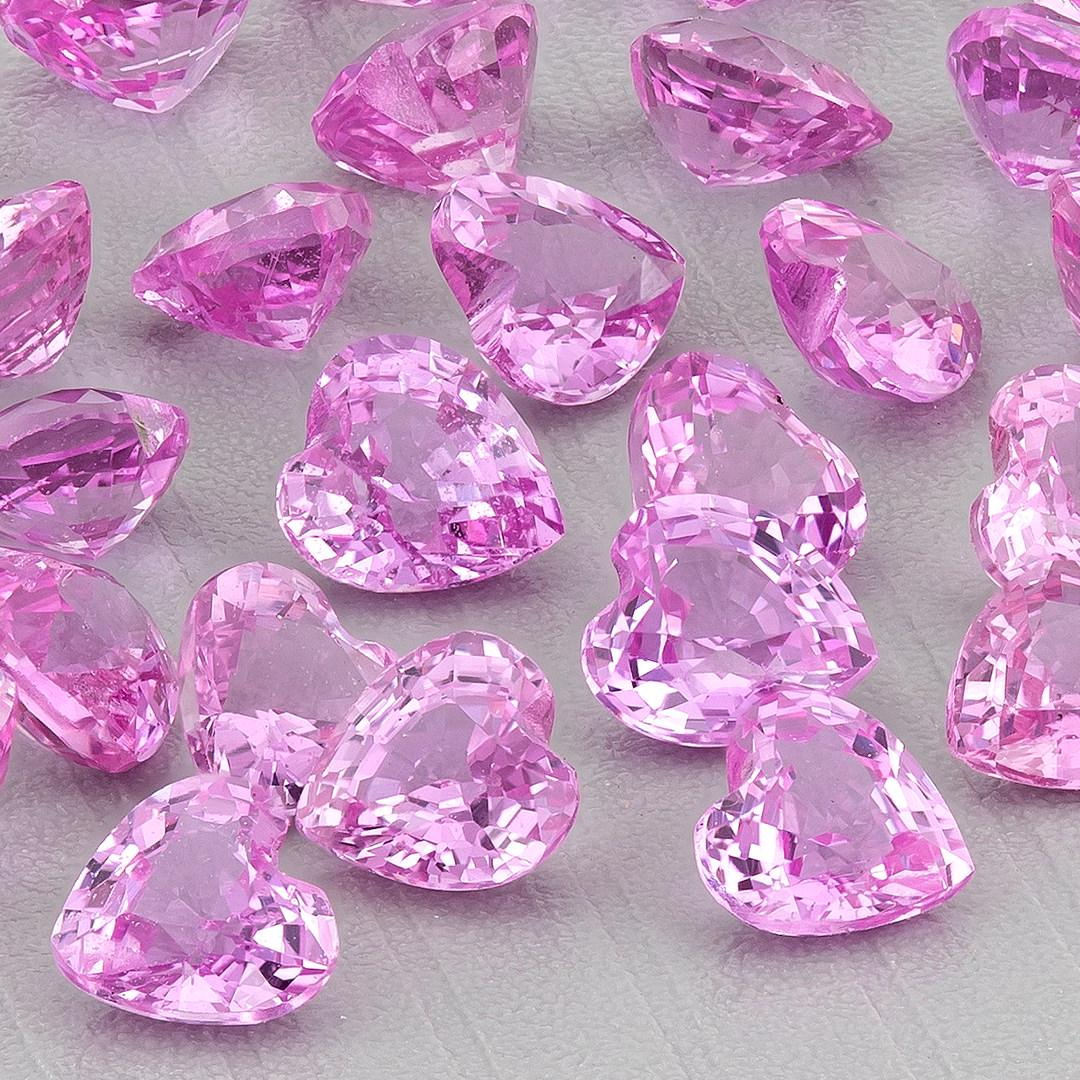 Closer view of the representative pink heart sapphire parcel, showing bright facet reflections and several side profiles.