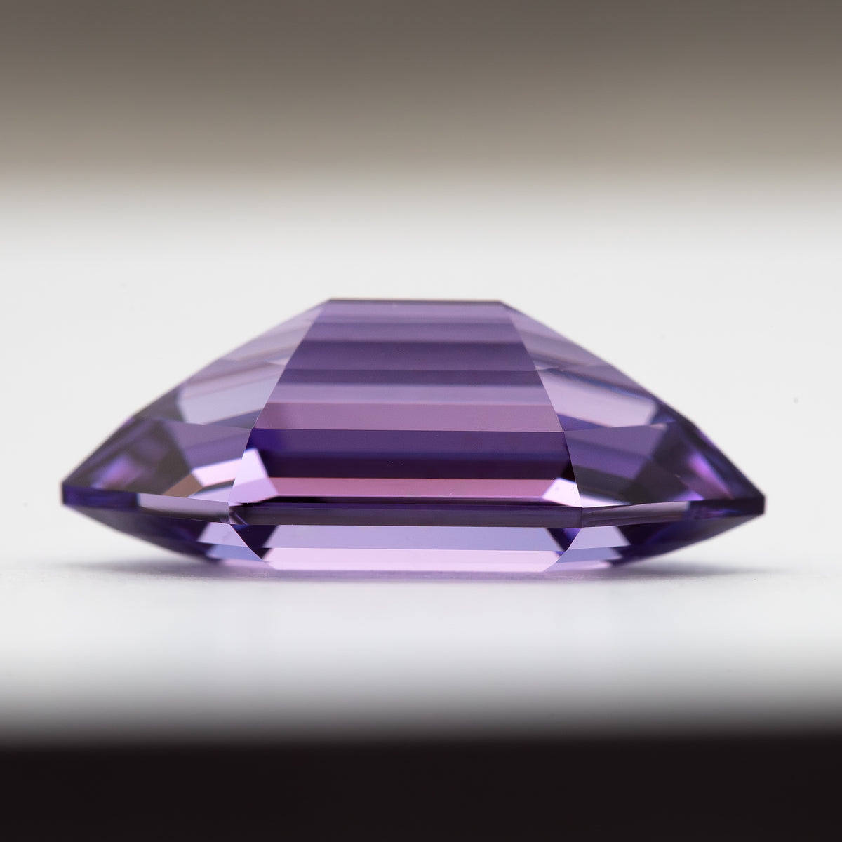 Perfil lateral del zafiro hexagonal violeta púrpura mostrando la corona, el filetín y el pabellón.