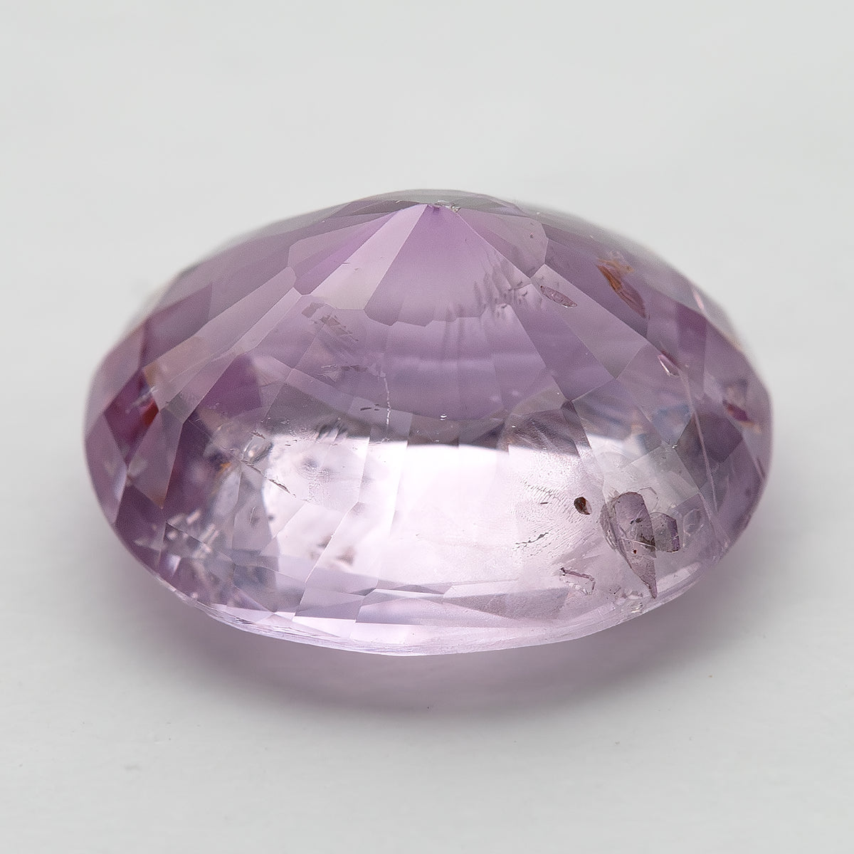 Low side profile of the pink oval sapphire, showing the crown, girdle and deep pavilion.