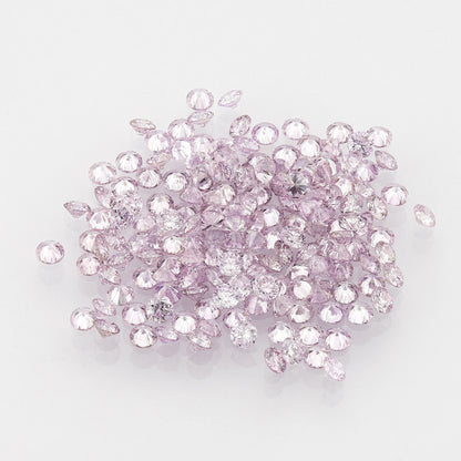 白い台の上に広げられた小さなラウンドピンクダイヤモンドのコレクション。