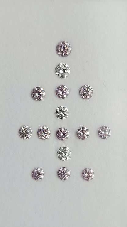 Face-up arrangement of twelve purple-pink diamonds and three white comparison diamonds on a neutral background.