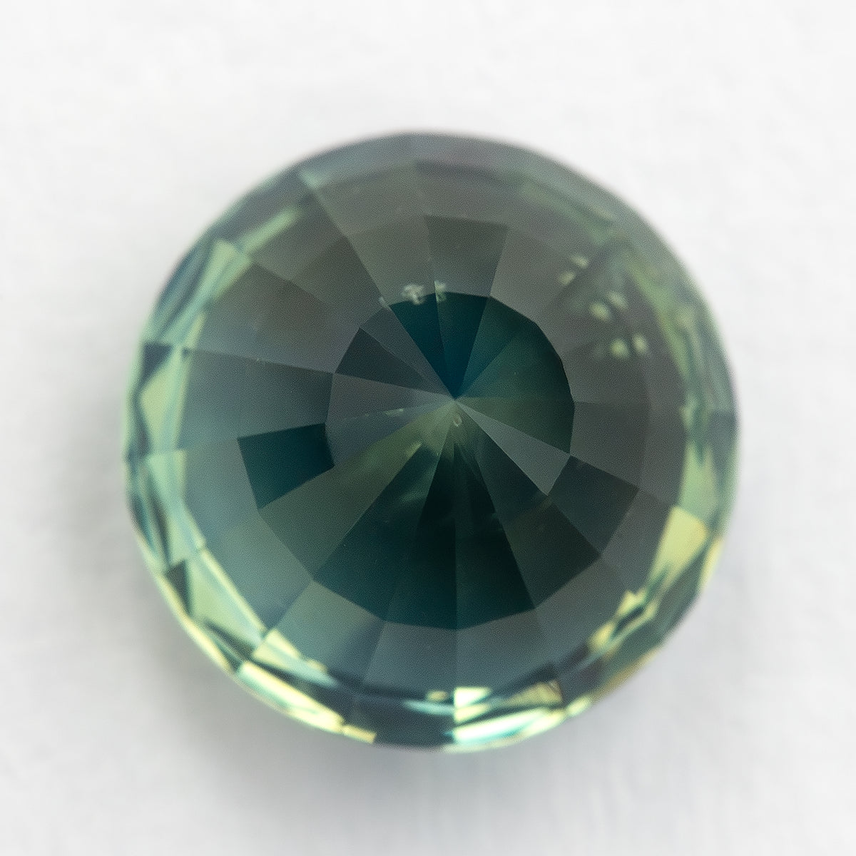 Reverse view of the deep teal blue green sapphire showing pavilion facets.