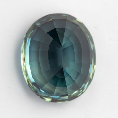 Pavilion-side view of the oval sapphire on white, with a pale blue-green centre and darker perimeter.