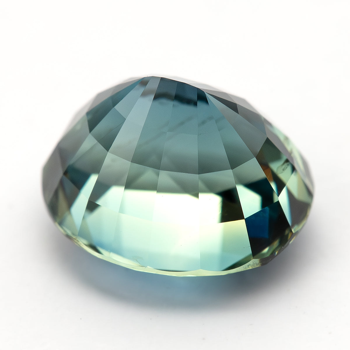 Angled pavilion view of the oval sapphire with light reflected along the lower facets.