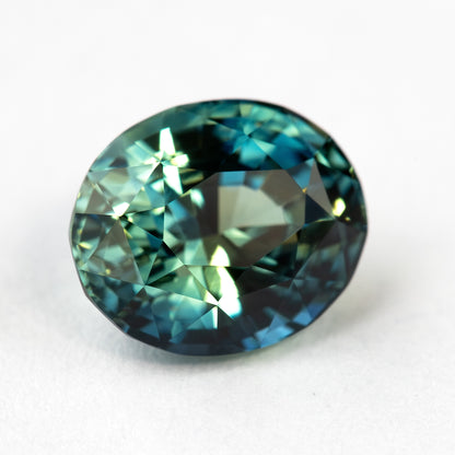 Rotated face-up macro view of the sapphire, showing another pattern of bright and dark blue-green reflections.