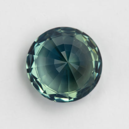 Teal blue-green round step-cut sapphire viewed from the pavilion side. View 19.