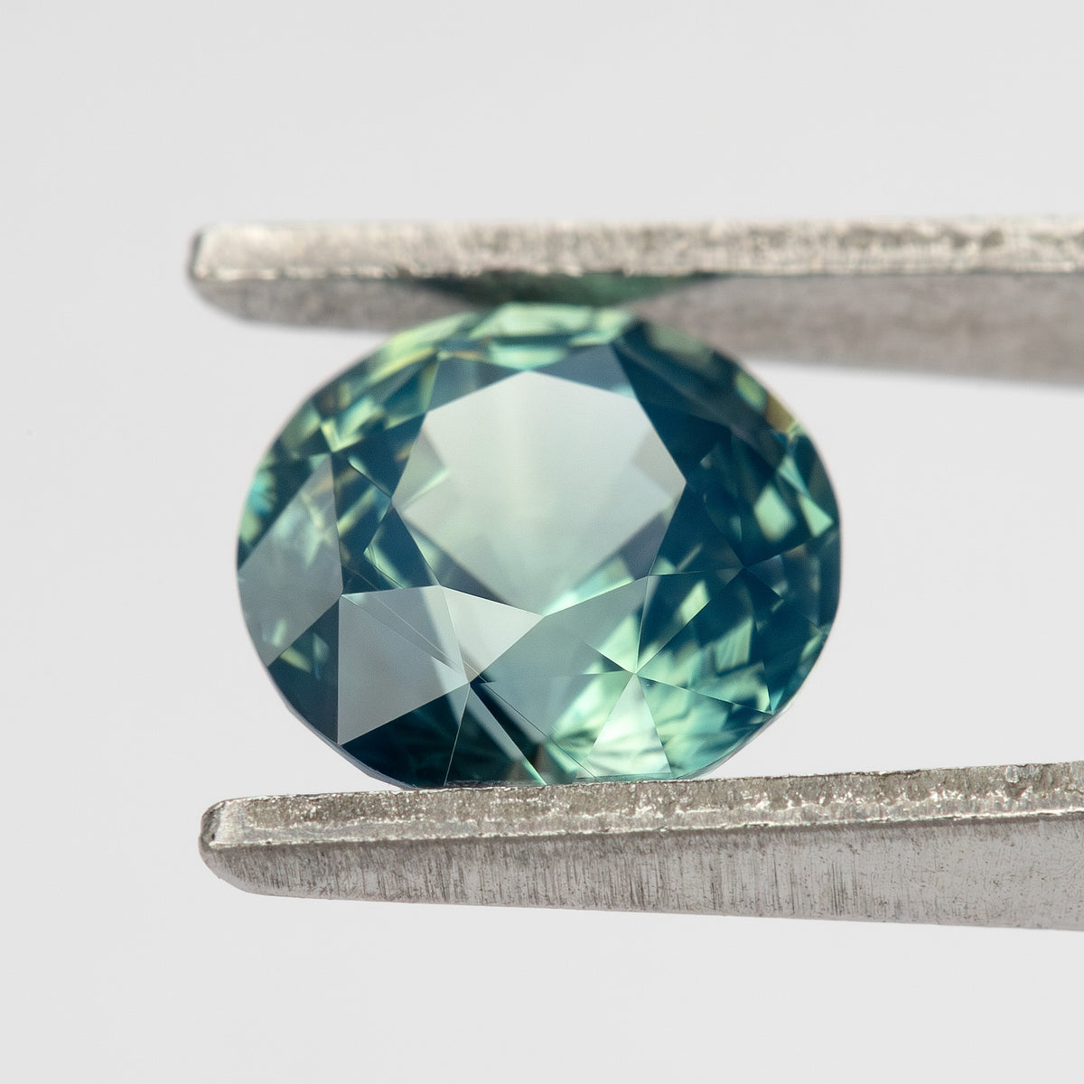 Teal blue-green round step-cut sapphire viewed face-up. View 11.