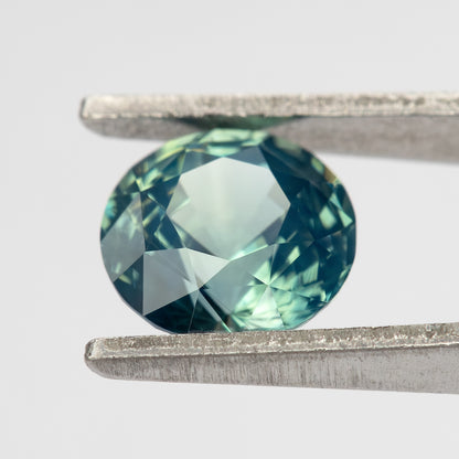 Teal blue-green round step-cut sapphire viewed face-up. View 11.
